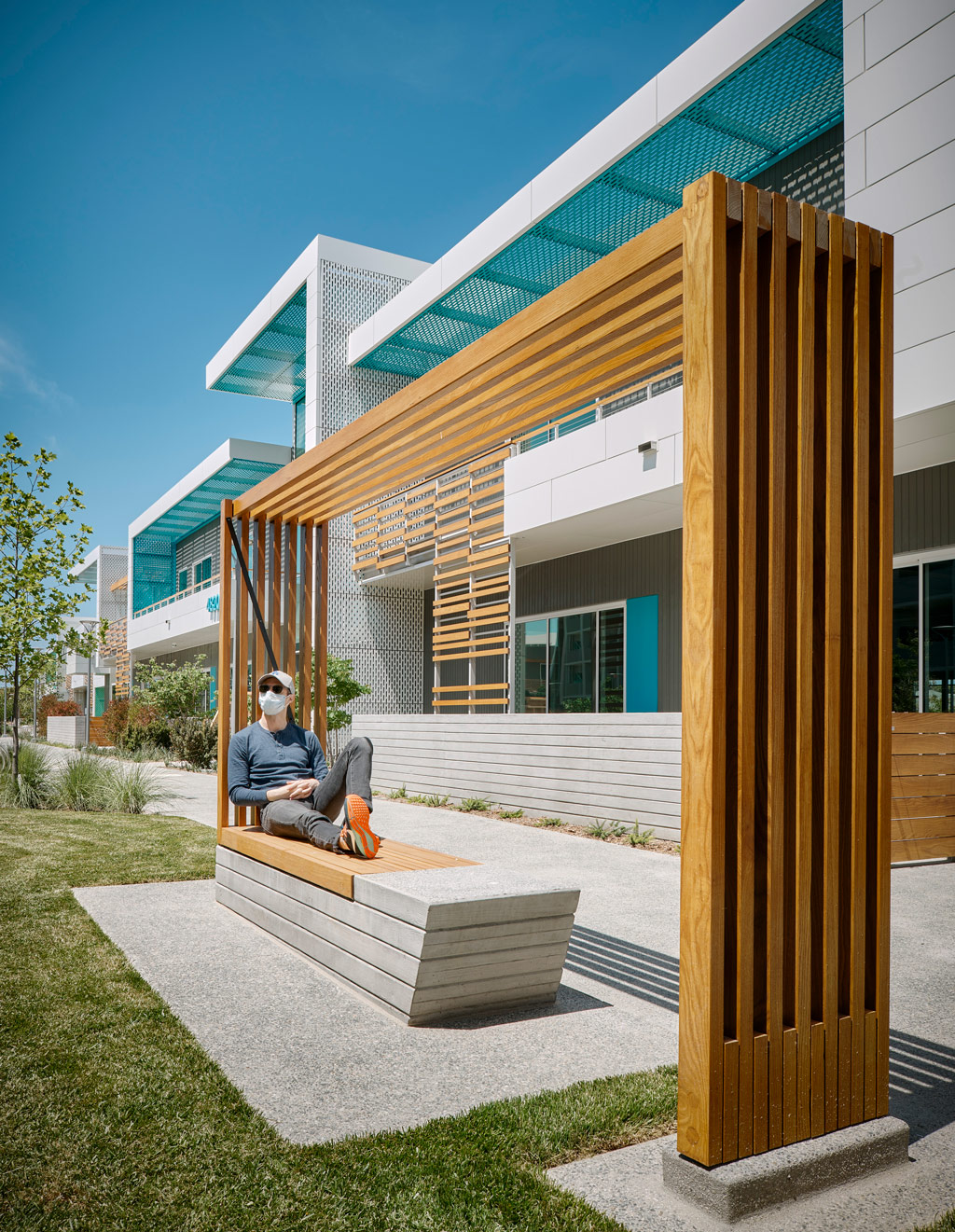 A person sitting on a bench outside a building.