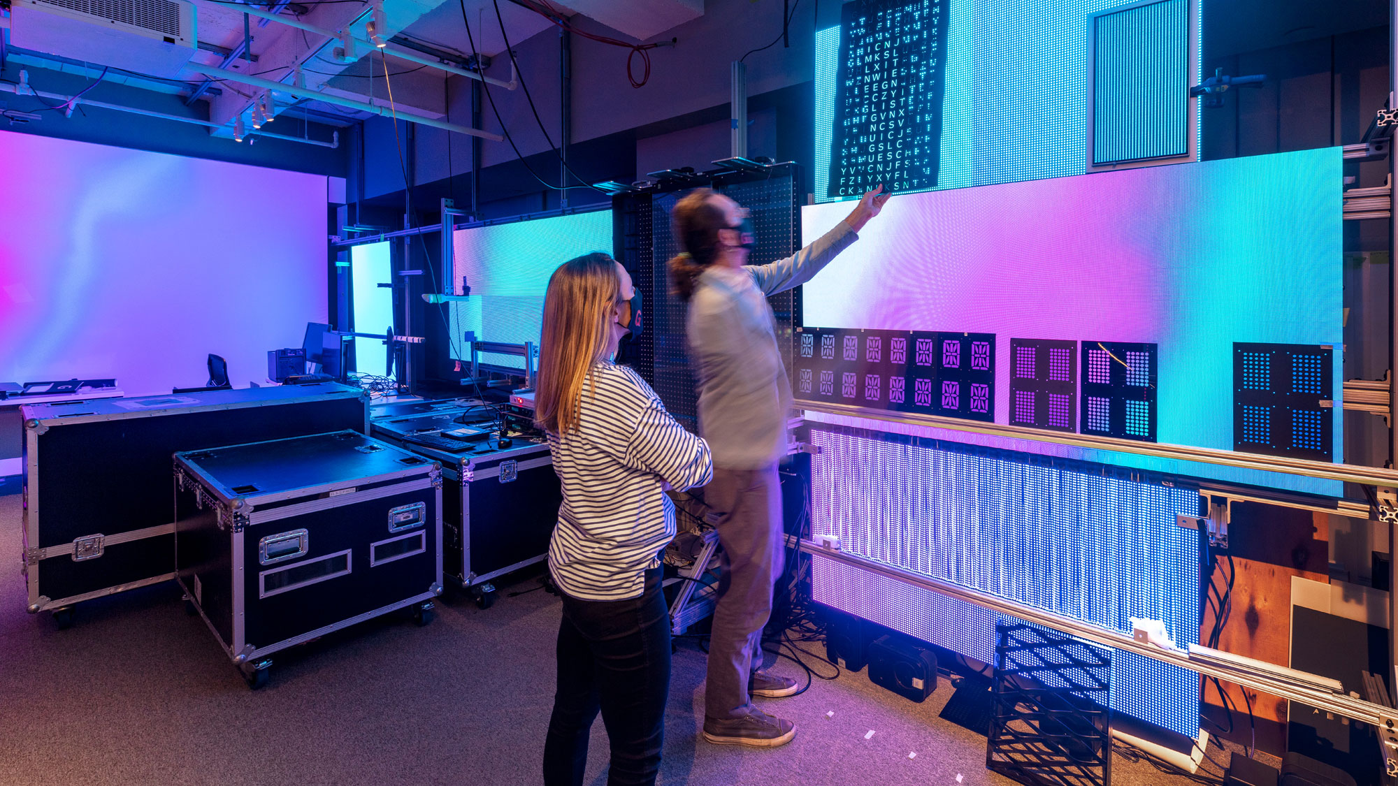 A couple of women in a room with a large screen and a large projector.