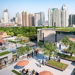 A group of people walking around a park in front of a large city.