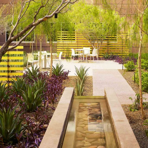 A patio with a yellow fence and trees.