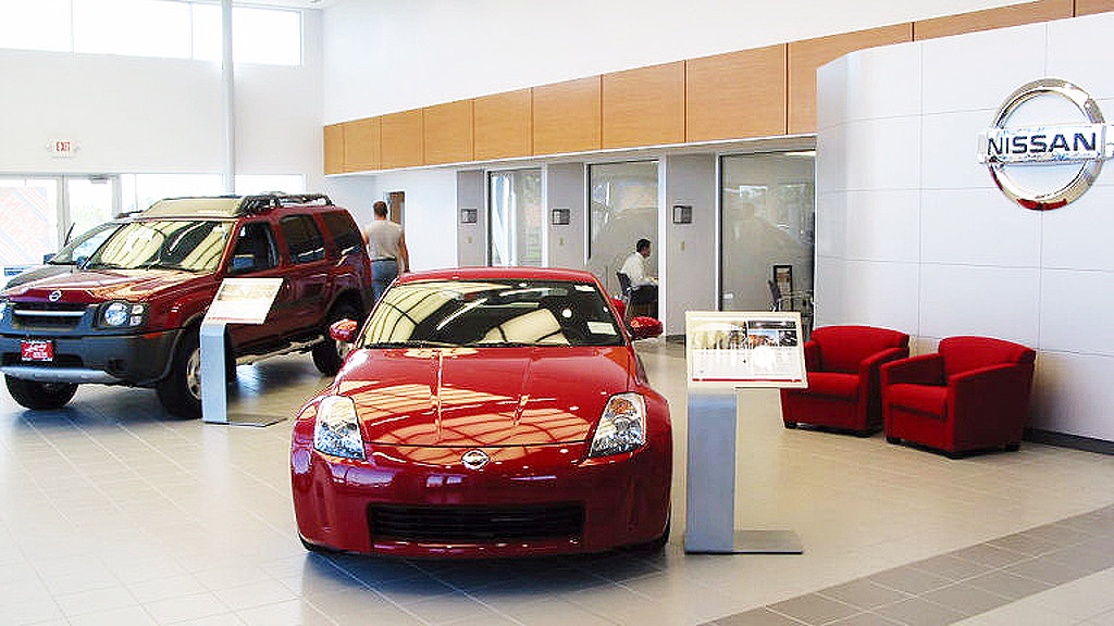 A car showroom with red chairs.