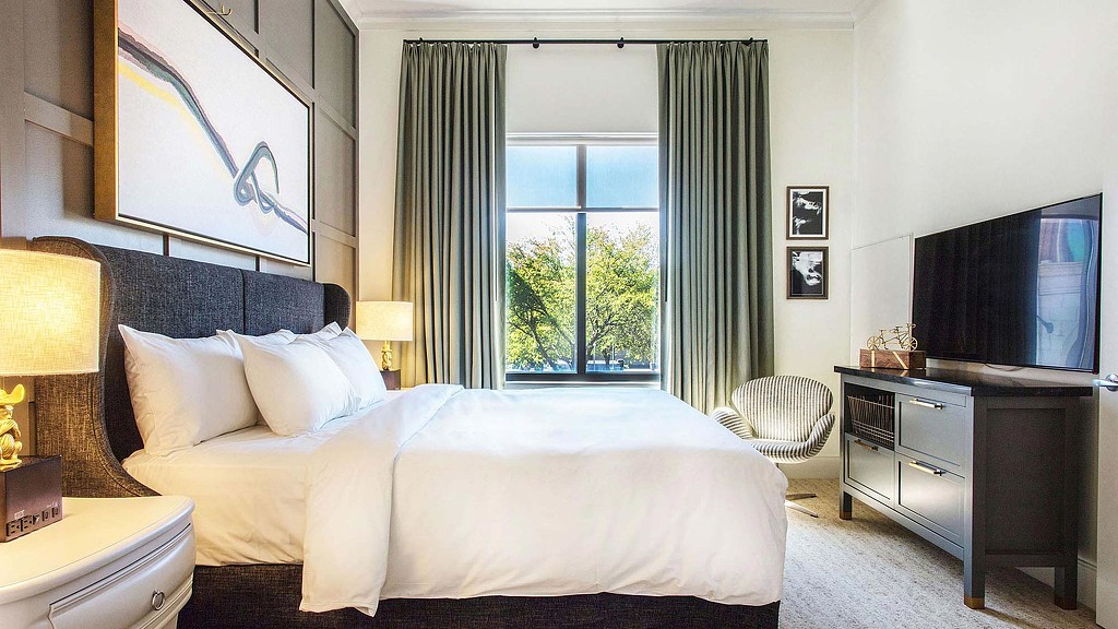 A bedroom with a large window.