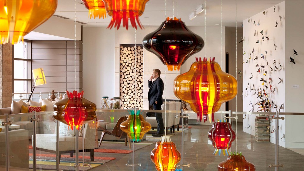 A person standing in a room with many vases and lamps.