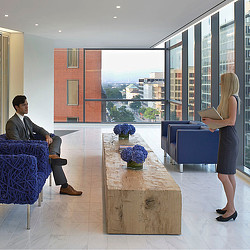 A woman standing next to a man sitting at a table.