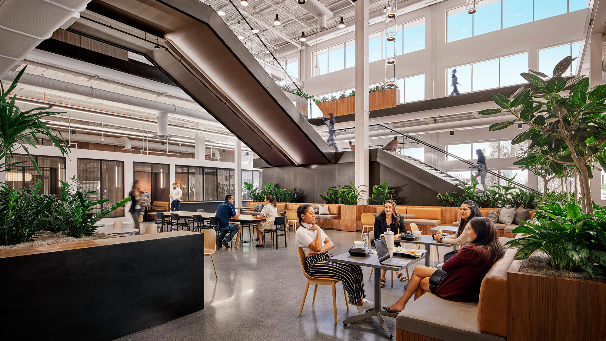 A group of people sitting at a table in a large building.