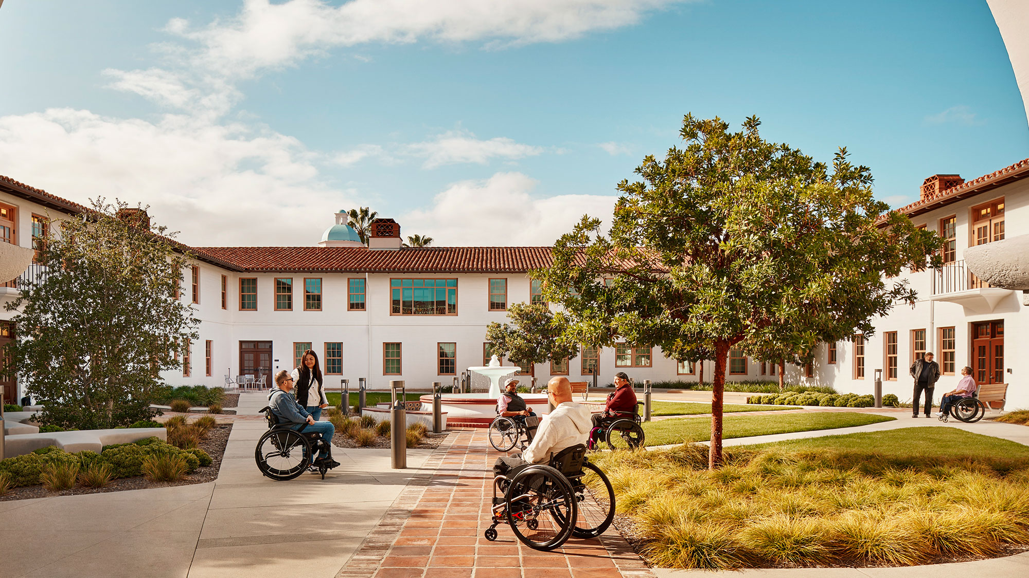 A group of people with wheelchairs gather outside a building.