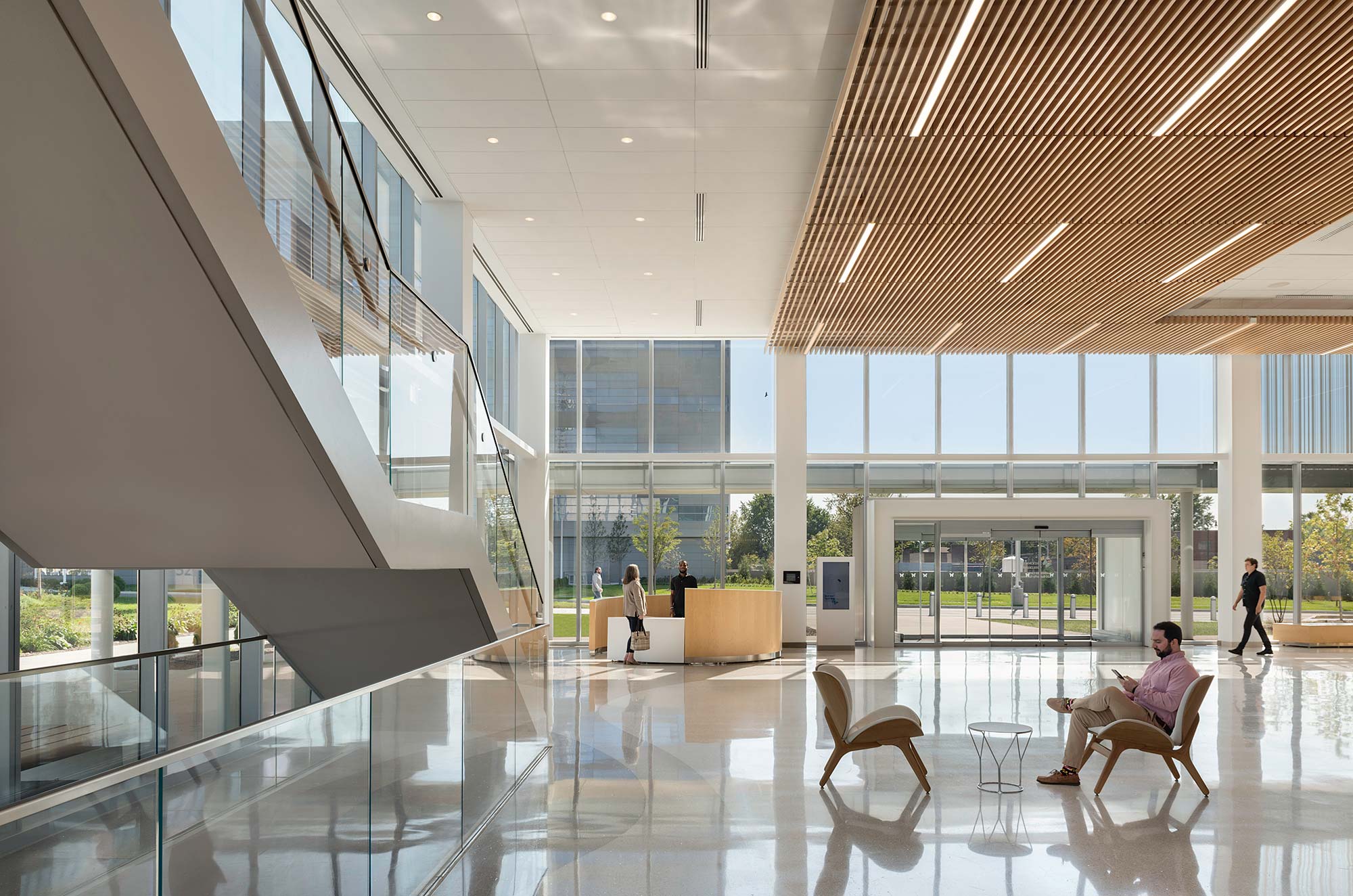 A large room with glass walls and people walking around.