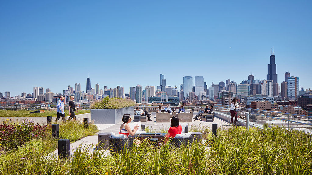 A group of people sitting at a table overlooking a city.
