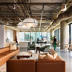A room with a couch and chairs.